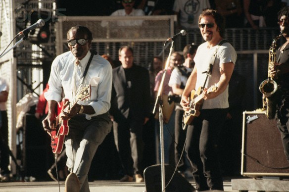 Chuck Berry duck walks with a smiling Bruce Springsteen watching. Rehearsal for September 1995 Rock and Roll Hall of Fame concert